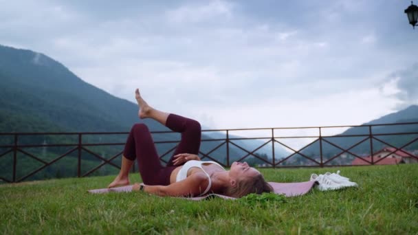 Stretching workout in park, woman is relaxing and flexing legs after training — Videoclip de stoc