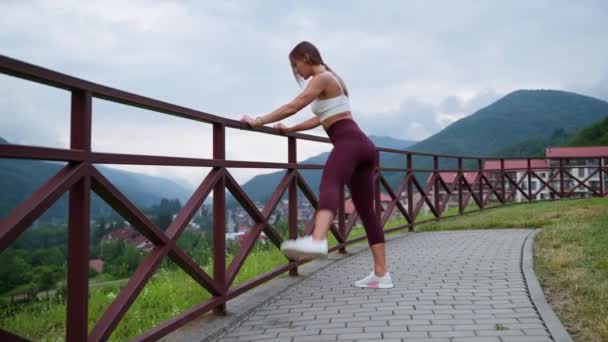 Woman stretching legs and enjoying nature scene — стоковое видео