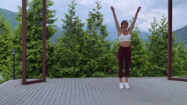 Breathing exercise after fitness workout, woman is relaxing and finishing exercising in park — Video