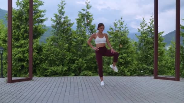トレーニングの前にウォーミングアップするために足の練習をするスポーツ女性 — ストック動画