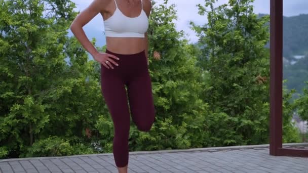 Femme sexy s'entraîne seule dans le parc, faisant des exercices de fitness, corps chauffant pour l'entraînement — Video
