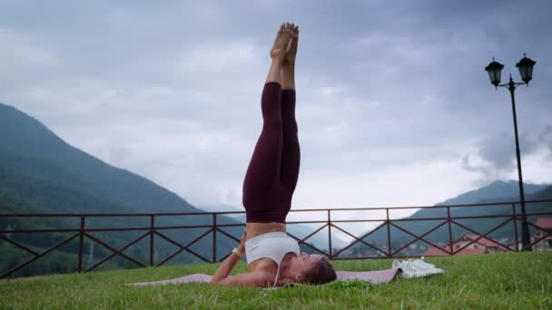 Woman in sarvangasana position is practicing yoga in nature, fitness and workout — Vídeo de Stock