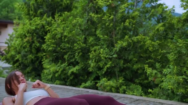 Woman doing abdominal crunches during outdoor workout — Video