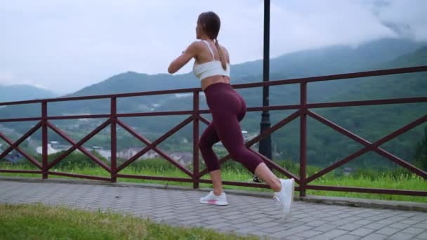 Athletic girl working out in the mountains — Video