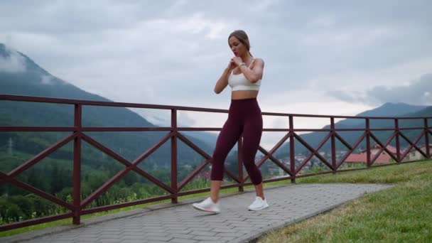 Woman working out in mountain village — стоковое видео