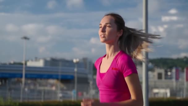 Fiatal szőke nő fut egyedül reggel a városban, tartja fitt és egészséges — Stock videók