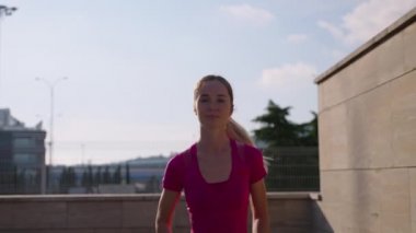 Genç fit sarışın dışarıda koşuyor.