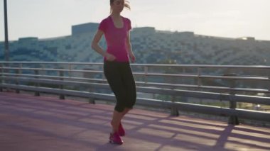 Fit girl jogger tying laces during morning training