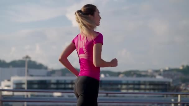 Healthy lifestyle and sport activities of city dwellers, young woman is jogging in morning — Stok video