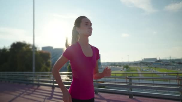 Active slim woman jogging outside in sunny morning — Stok video