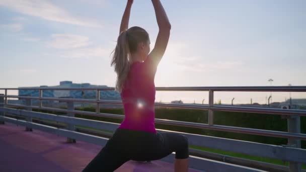 Athletic woman is doing morning workout and yoga asana outdoors in city — Stok video