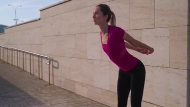 workout in morning time outdoors in city, young woman is doing physical exercises