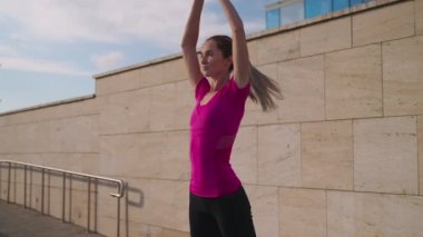 Güneşli bir sabahta şehirde genç bir bayanın sabah sporu, yoga ve meditasyon.
