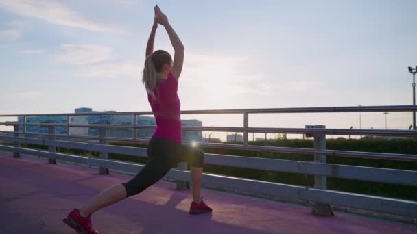 Sportlerin praktiziert morgens in der Stadt Yoga im Freien — Stockvideo