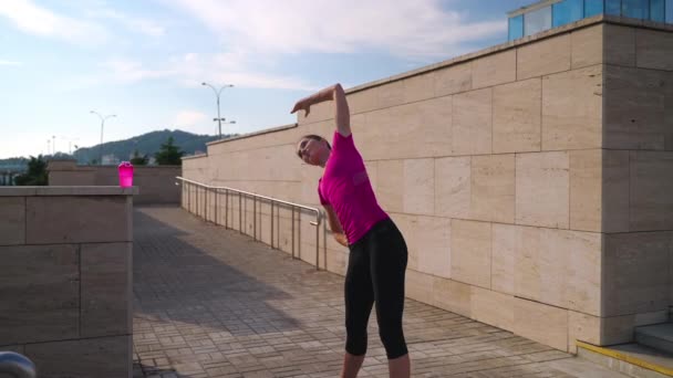 Urban girl warming up before morning jog — Stok video