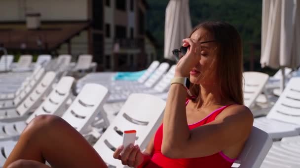 Fille en utilisant un bâton de crème solaire pour protéger le visage contre les dommages du soleil — Video