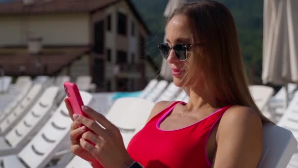 Hotel convidado relaxante junto à piscina com telefone celular — Vídeo de Stock
