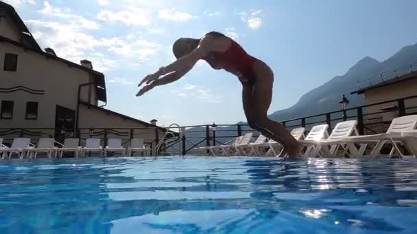 Γυναίκα βυθίζεται σε εξωτερική πισίνα και κολύμπι κάτω από το νερό — Αρχείο Βίντεο