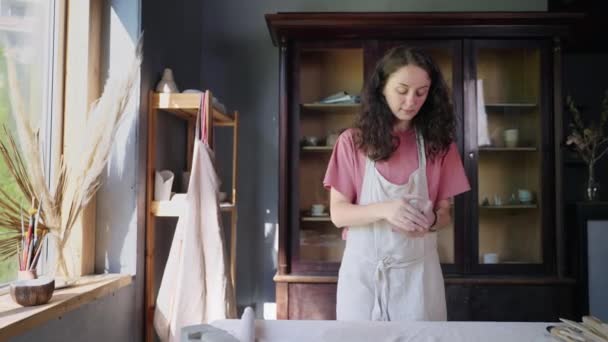 女艺术家正在她的陶器作坊工作，雕刻粘土 — 图库视频影像