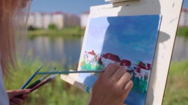 Şehir manzarasını doğadan resmediyorum. Resimli gölün kıyısındaki parkta.