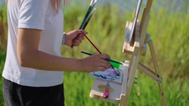 Doğadan önce resim yaparken yağları harmanlayan sanatçı