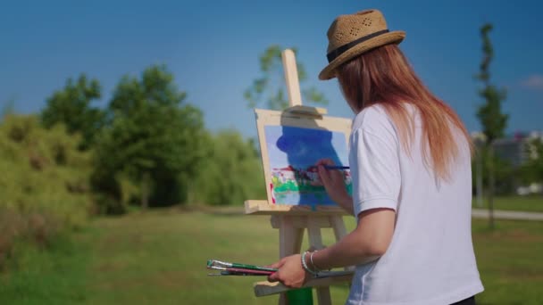Artista mulher está passando fim de semana no parque e pintura paisagem — Vídeo de Stock