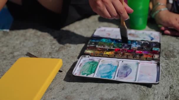Kunstenaar is met behulp van aquarelle voor het schilderen van beeld, het nemen van blauwe kleur door borstel — Stockvideo