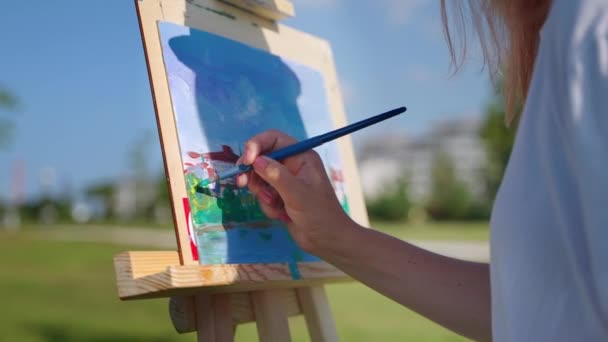 Kobieta artystka prawie skończyła malować plenerem — Wideo stockowe