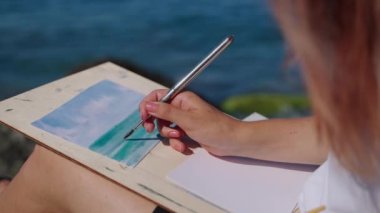 Suluboya deniz manzarası yaratan kadın sanatçı