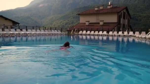 Nadadora femenina está nadando en la piscina al aire libre en el hotel en lugar ecológico con increíbles vistas a las montañas — Vídeos de Stock