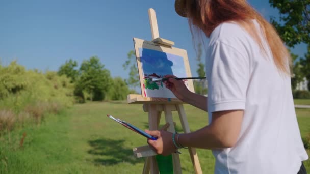 Картина з природи, жінка художник малює на відкритому повітрі влітку — стокове відео