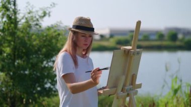 Hafta sonu parkta resim çizmek, genç bir kadının yaratıcı hobisi.