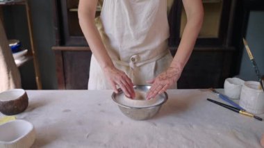 El yapımı seramik yapıyorum. Potter kaseyi parlatıyor.