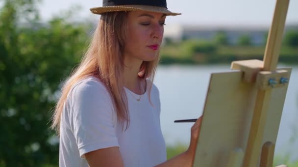 Художница, наслаждающаяся пленэрной живописью — стоковое видео