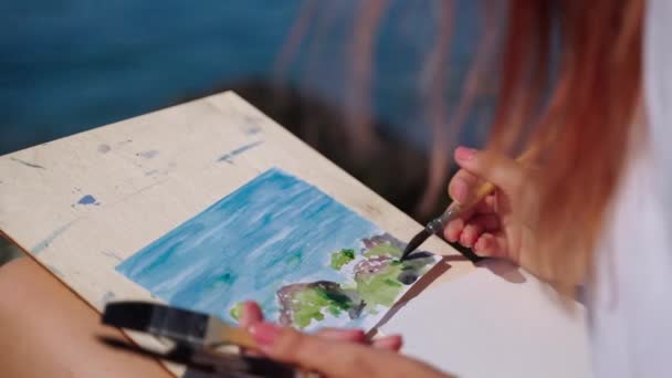 Kvinna tillbringar fritid med akvarell målning vid havet — Stockvideo