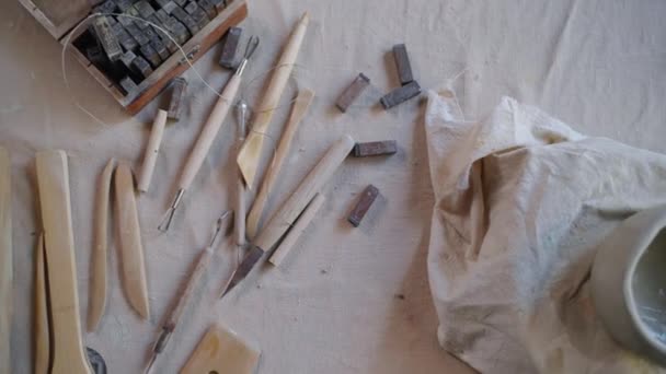 Внутри мастерской гончара, рабочий стол с профессиональными инструментами и заготовкой глиняного горшка — стоковое видео
