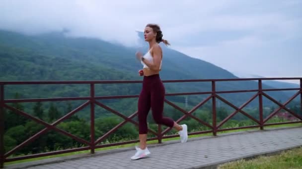 Sexy feminino corredor está treinando de manhã, correndo sozinho no parque em pequena cidade de montanha — Vídeo de Stock