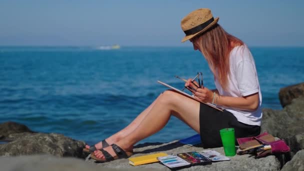 바다 근처에서 그림을 그리며 휴식을 취하는 여자 — 비디오