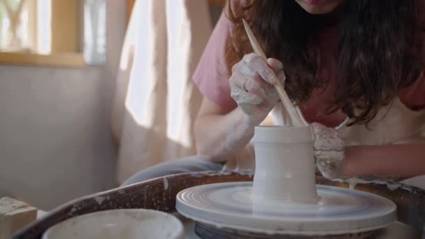一个女陶工用工具和陶瓷轮慢慢拍摄泥壶的镜头 手工制作陶瓷制品的工艺 — 图库视频影像