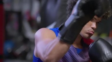 Genç Afro-Amerikalı adamın kutu eğitimi, yakışıklı genç adam yumrukluyor kum torbası, Afrikalı sporcunun portresi