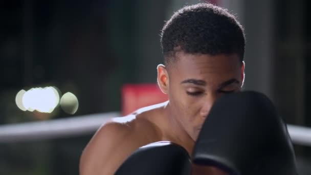 若い黒人のティーンエイジャーはボクシングクラブで訓練していますアフリカ系アメリカ人のボクサーは春にパンチと防衛を練習しています — ストック動画