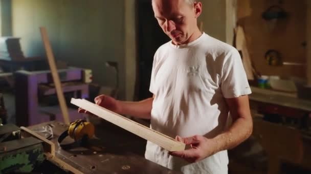 Człowiek Stolarz Patrzy Obrabiany Przedmiot Obróbce Produkcja Profili Drewnianych Frezarką — Wideo stockowe