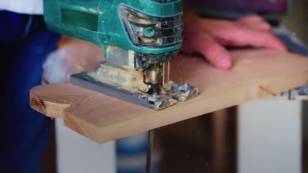 一名木工用电锯在木板上刻出弯曲形状的特写镜头 制作一个切割板 — 图库视频影像