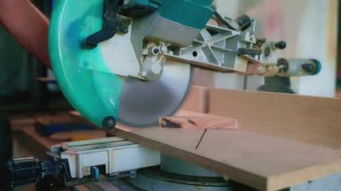 Ahşap işçiliği yapılıyor. Marangoz atölyede tahta kesmek için testere kullanıyor.