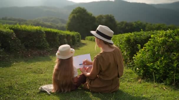 有爱心 有爱心的母亲和女儿一起在安静的山村里消磨时光 教她绘画和热爱大自然 — 图库视频影像