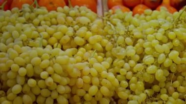 Organik ve eko marketin vitrininde taze beyaz üzüm, süpermarkette meyve reyonu, tatlı meyvelerin yakın çekim görüntüsü, vitamin zengini yiyecekler.
