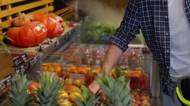 Erkek müşteri markette tutku meyvesi seçiyor, organik gıda ve egzotik meyvelerle alışveriş yapıyor, süpermarketten lezzetli ve tatlı meyveler alıyor, tatlı ve kokteyl pişiriyor.