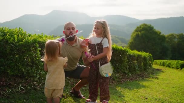 在大自然的快乐周末 爸爸和他的小女儿们在吹泡泡 夏天的家庭娱乐 爸爸和小女孩 — 图库视频影像
