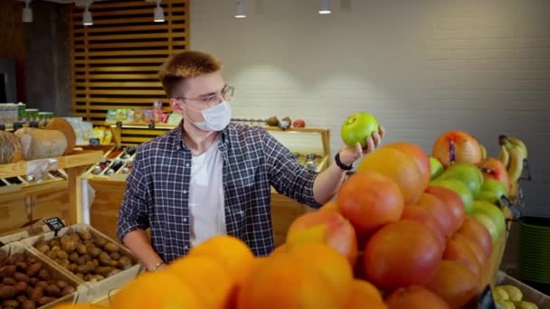 Jeune Homme Avec Masque Facial Achète Des Fruits Dans Épicerie — Video