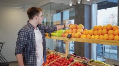 Adam marketten greyfurt alıyor, marketten taze meyve alıyor, vejetaryen marketten alışveriş yapıyor, sağlıklı yaşam tarzı, meyve yiyor.
